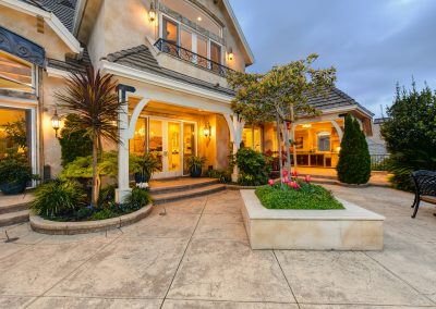 luxury two-story home at dusk with lights on